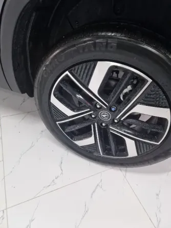 Красивый новый автомобиль с большим красным бантом, установленный в салоне с воздушными шарами