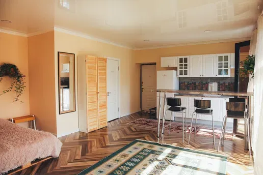 Современный интерьер квартиры с кухней и обеденной зоной, светлые тона, деревянный пол