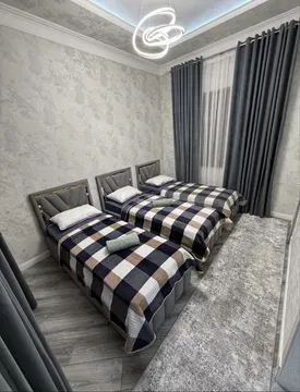 Просторная спальня с двумя кроватями и современными текстилями