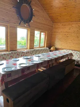 Просторная комната с длинным столом и окнами, выходящими на природу