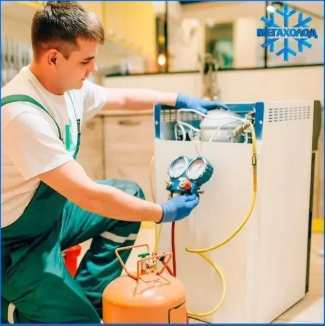 Тоңазытқыш пен газ баллонымен жұмыс істеп жатқан манометрмен мастер.