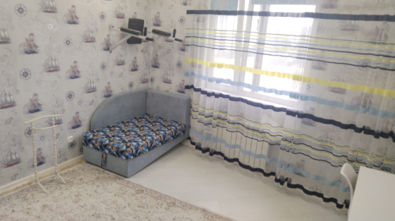 Жұмсақ диванмен, кристалды шаммен және декоративті жастықшалармен жабдықталған бөлме