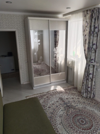 Жұмсақ диванмен, кристалды шаммен және декоративті жастықшалармен жабдықталған бөлме