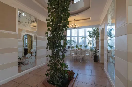 Уютный обеденный зал с большим столом и телевизором на стене