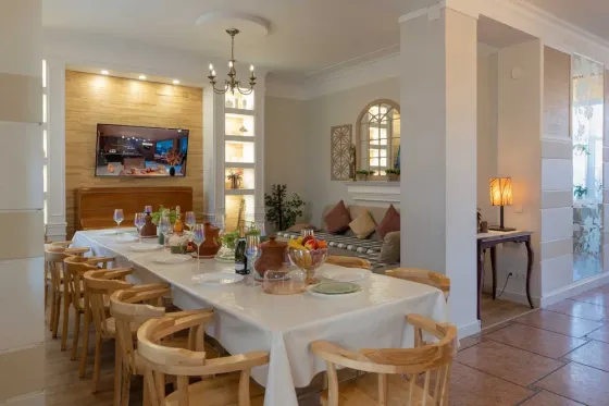 Уютный обеденный зал с большим столом и телевизором на стене