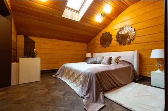 Бассейн на открытом воздухе с вечерним освещением и деревянным домом на фоне