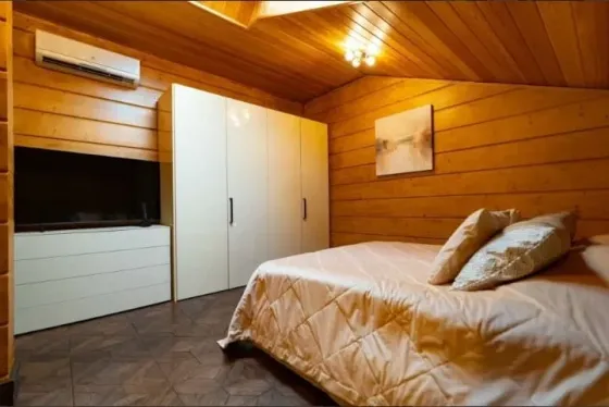 Бассейн на открытом воздухе с вечерним освещением и деревянным домом на фоне