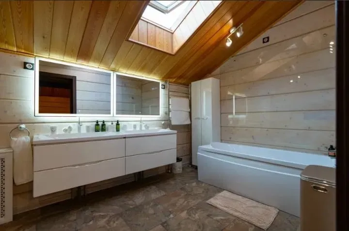 Современная ванная комната с душем и ярким деревянным потолком