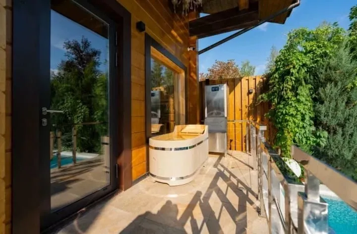 Уютная терраса с джакузи и зелеными растениями вокруг