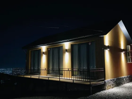 Деревянный дом с подсветкой ночью