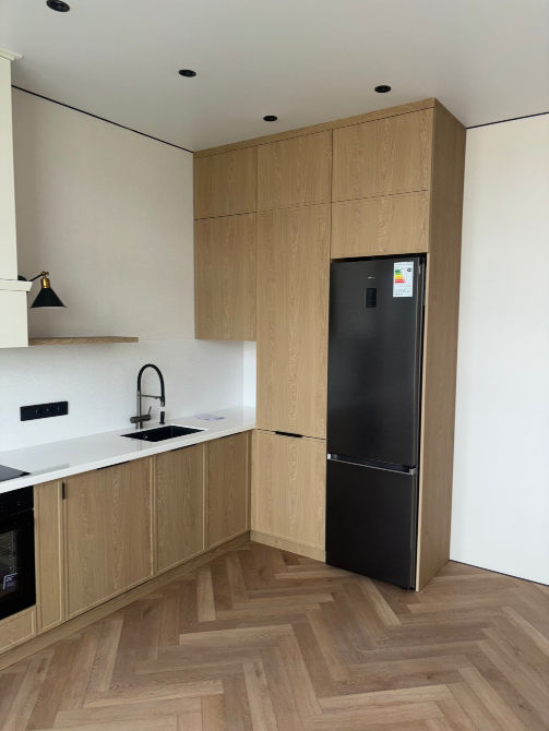 Угол кухни с холодильником и интегрированными шкафами