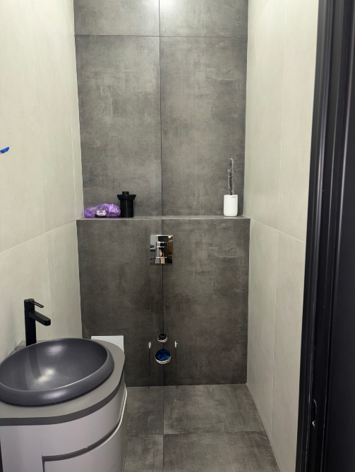 Минималистичный туалет с серыми стенами и современной сантехникой