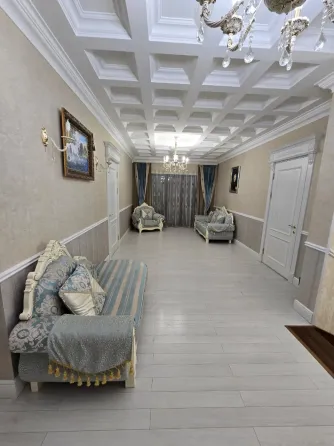 Просторная и элегантная столовая с мебелью из темного дерева и красивым освещением