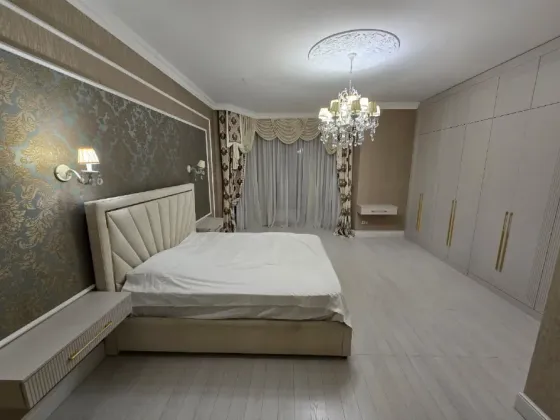 Просторная и элегантная столовая с мебелью из темного дерева и красивым освещением