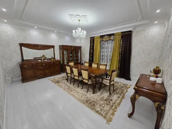 Просторная и элегантная столовая с мебелью из темного дерева и красивым освещением