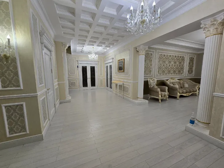 Просторный коридор с колоннами и стильной мебелью