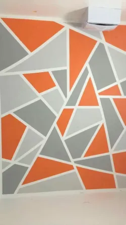 Геометриялық өрнегі бар сұр фондағы қабырға