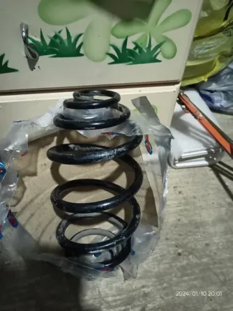 Резиновая пружина, упакованная в прозрачный пакет, на фоне предметов в мастерской