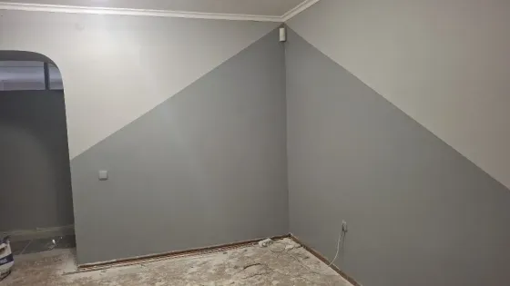 Стены с декоративной покраской в серых тонах и угловая планировка комнаты