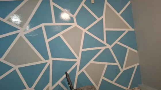 Стены с декоративной покраской в серых тонах и угловая планировка комнаты