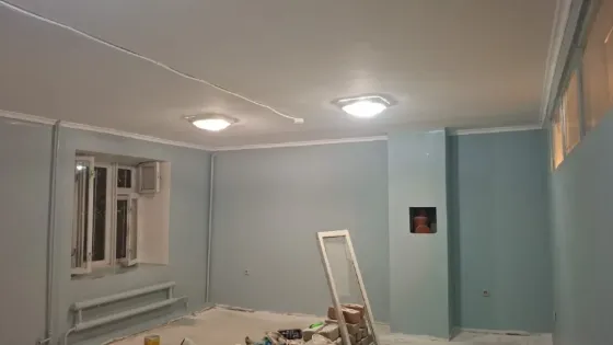 Стены с декоративной покраской в серых тонах и угловая планировка комнаты