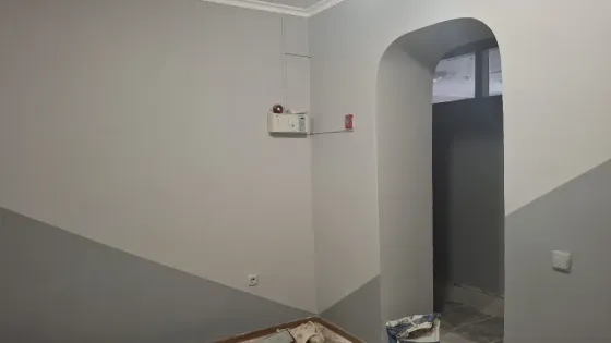 Стены с декоративной покраской в серых тонах и угловая планировка комнаты