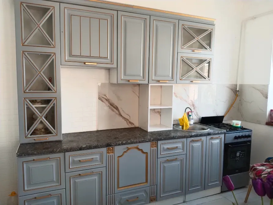 Интерьер кухни с серыми шкафами и черной плитой, стильный дизайн