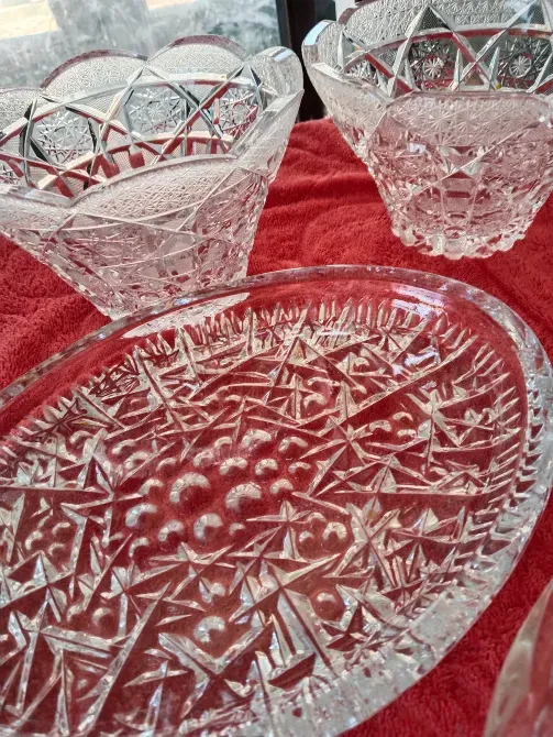 Набор изысканной хрустальной посуды, включая тарелку и две чаши, на красной ткани