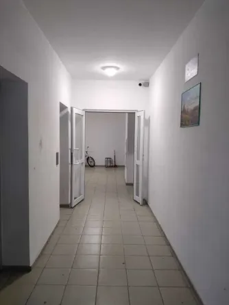 Длинный коридор с дверью и полкой для хранения