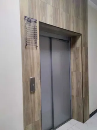 Длинный коридор с дверью и полкой для хранения