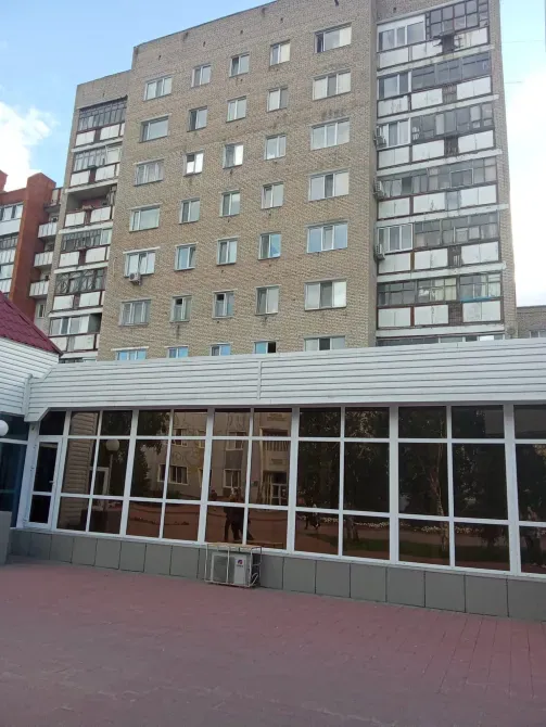 Фасад многоквартирного дома с окнами и местом для отдыха