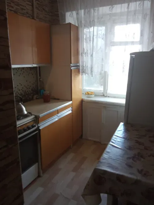 Кухня в квартире с мебелью, окном и кухонной техникой