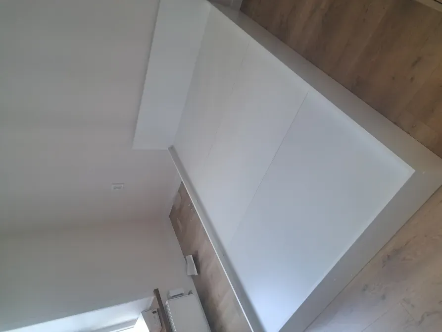 Матрассыз ақ төсек, бөлмедегі бүйір көрінісі