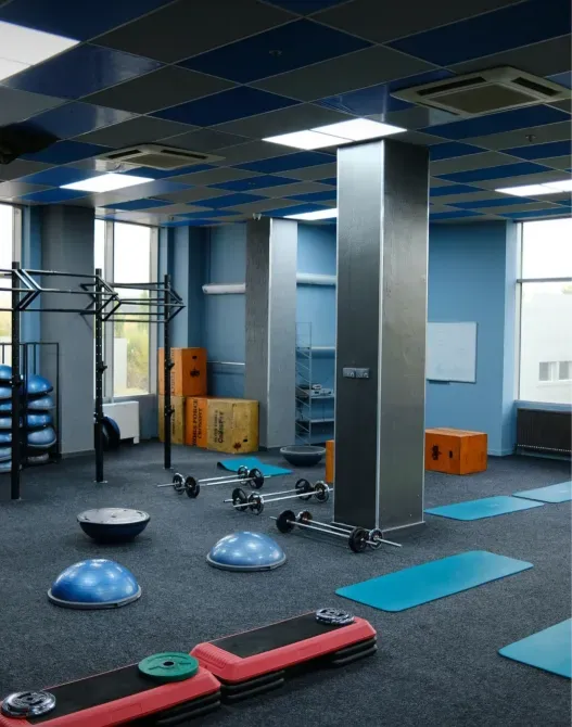 Фитнес-зал с различным спортивным оборудованием и тренажерами