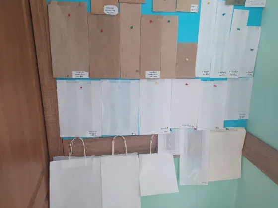 қағаздан жасалған қаптама үлгілерінің коллекциясы қабырғада