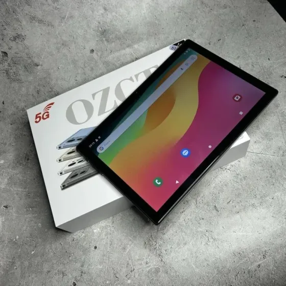 Планшет на белом фоне рядом с коробкой с надписью 