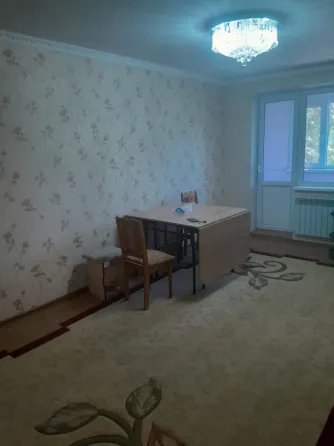 Кухня с оранжевыми шкафчиками и газовой плитой, окно с видом на greenery