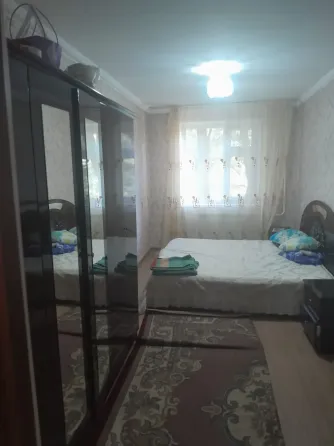 Кухня с оранжевыми шкафчиками и газовой плитой, окно с видом на greenery