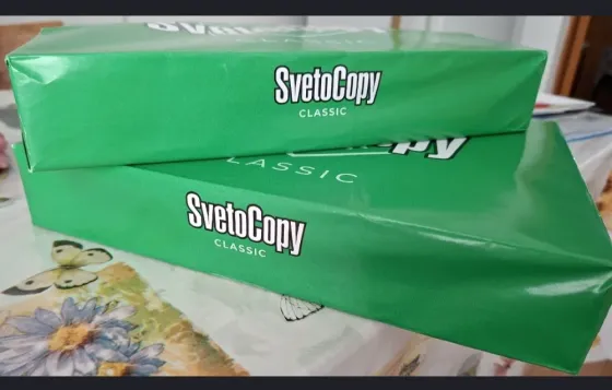 Зеленые упаковки бумаги SvetoCopy Classic располагаются на столе с цветочным рисунком