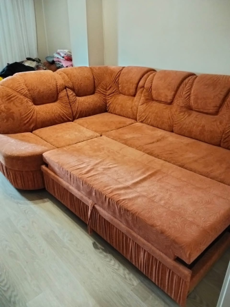 Қызғылт-сары жұмсақ жабынмен жабдықталған диван, жұмсақ жастықшалары мен сақтау бөлімі бар