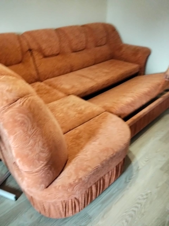 Қызғылт-сары жұмсақ жабынмен жабдықталған диван, жұмсақ жастықшалары мен сақтау бөлімі бар