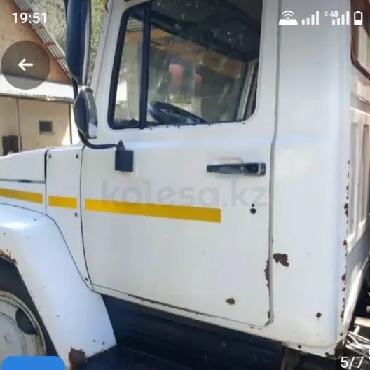 Белый грузовик с желтой полосой, вид спереди