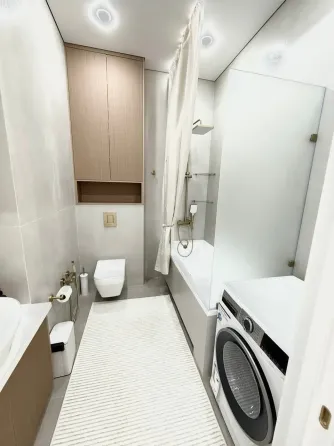 Современная спальня с мягким текстилем и стильной люстрой