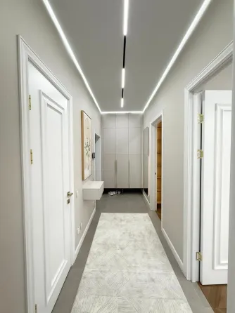 Современная спальня с мягким текстилем и стильной люстрой