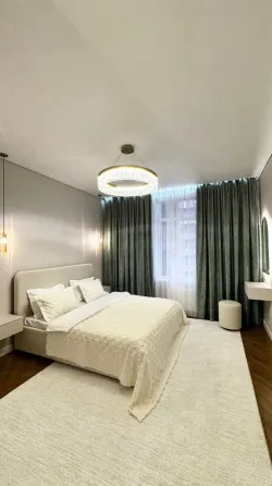 Современная спальня с мягким текстилем и стильной люстрой