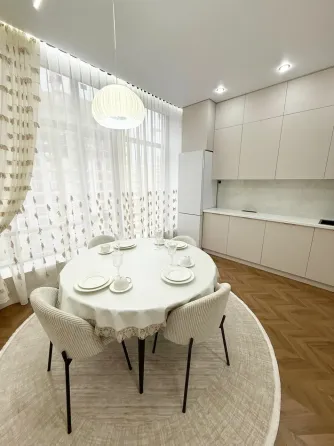 Современная спальня с мягким текстилем и стильной люстрой