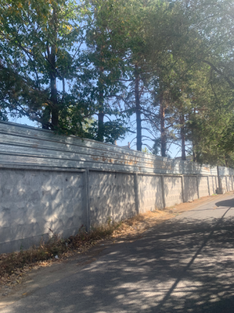 узкая дорожка между домами с металлическим забором