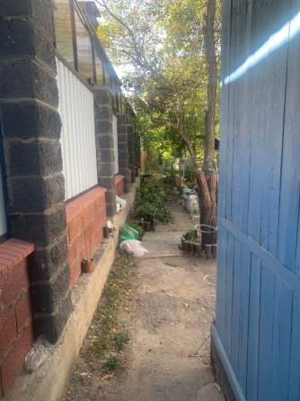 узкая дорожка между домами с металлическим забором