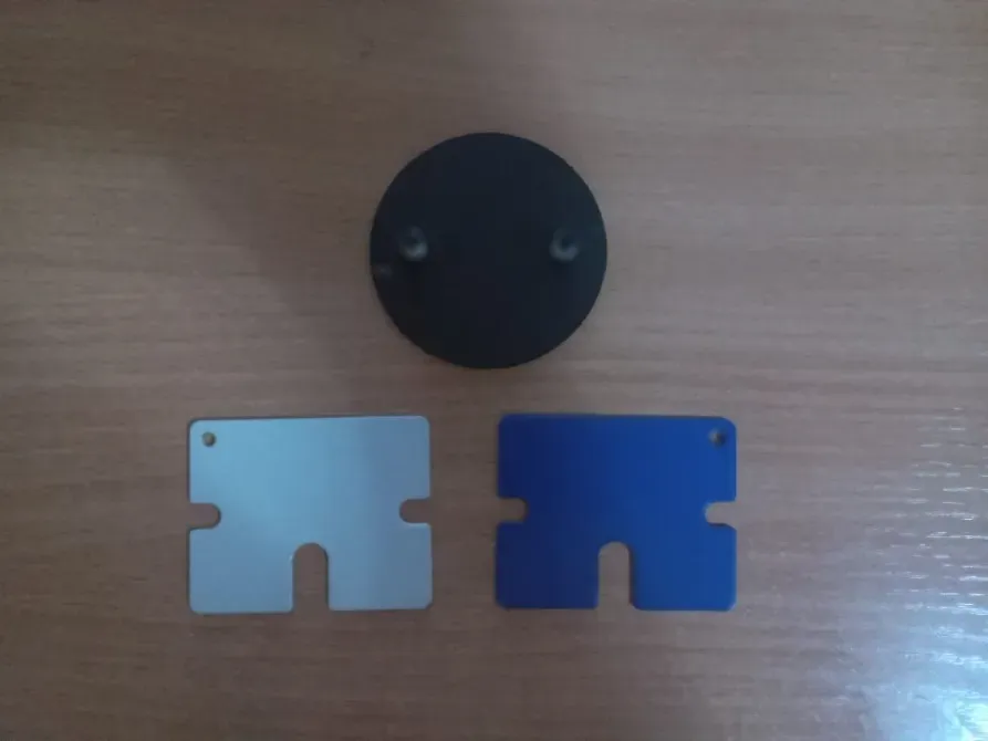 Сол сурет: стол үстінде үш зат, қара дөңгелек нысан және екі карта