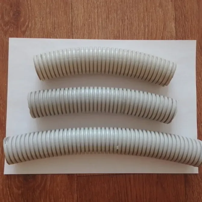 Три гибких пластиковых шланга разной длины и диаметра, уложенных на белом фоне